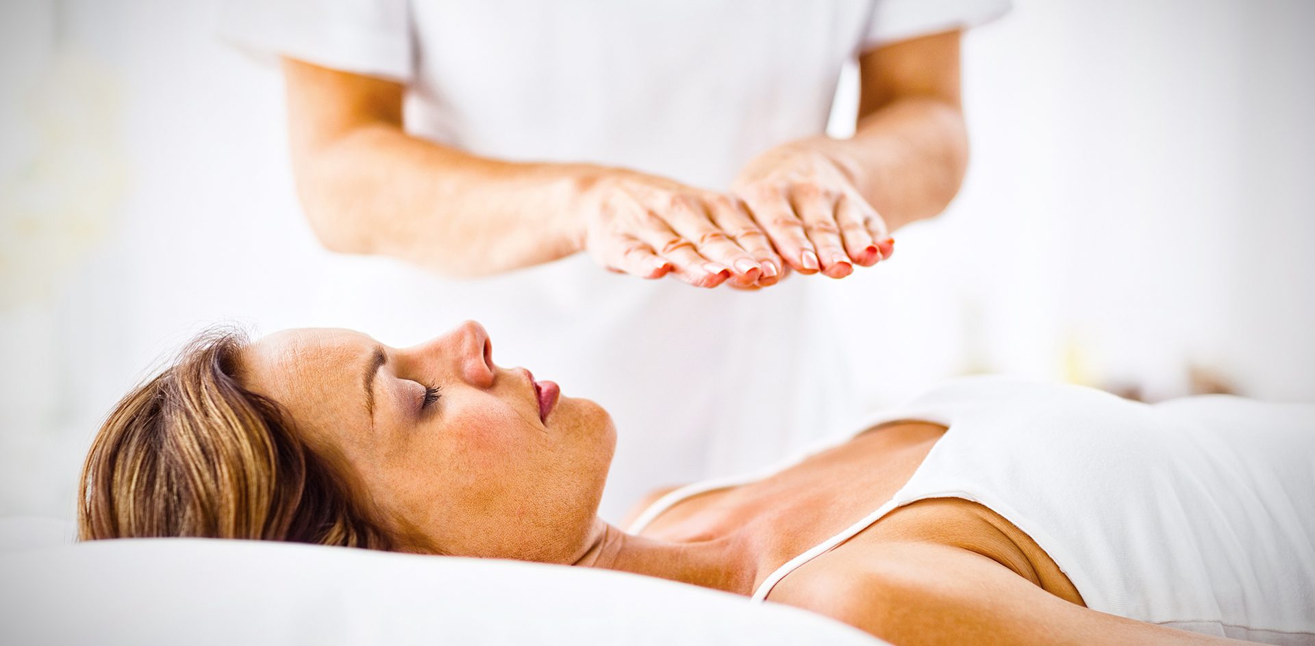 young woman receiving energy healing treatment